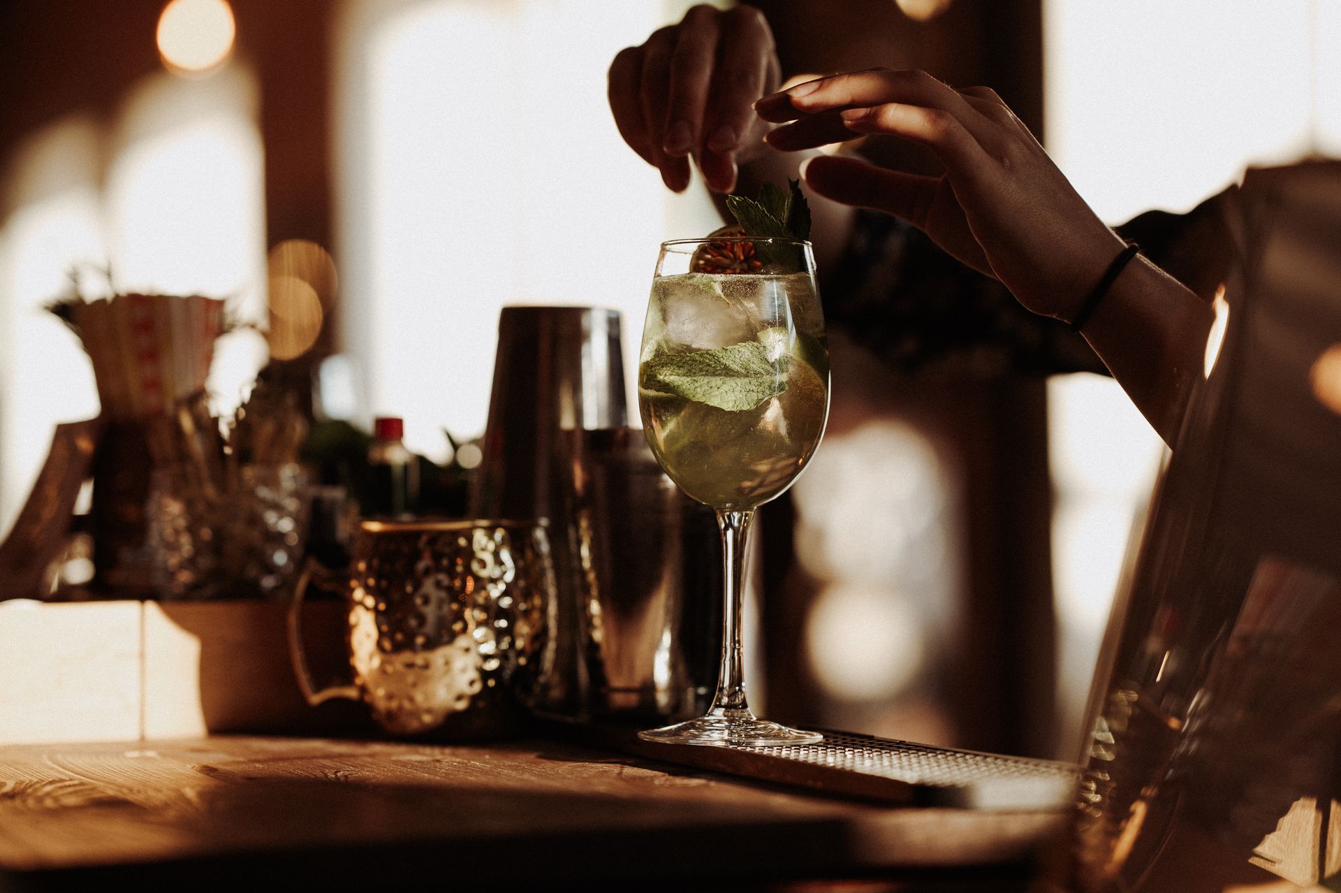 Barman dekorujący koktajl świeżą miętą